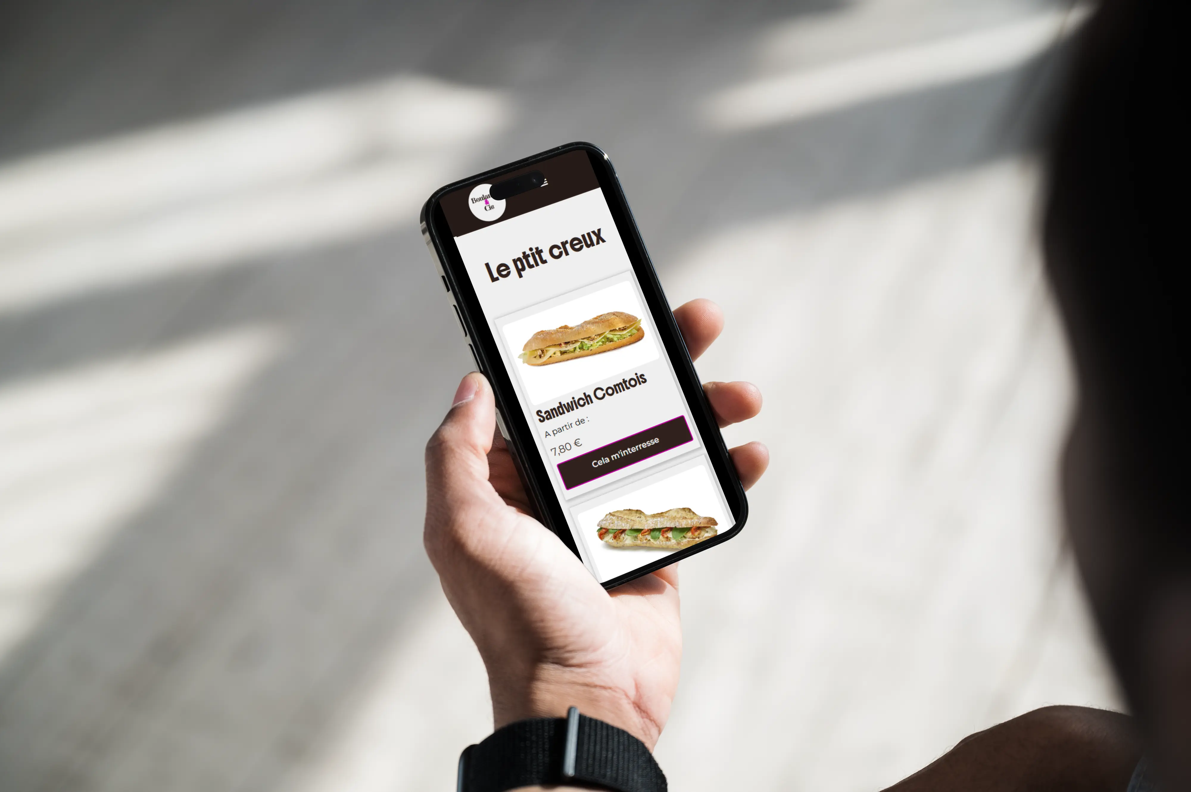 Un écran de smartphone affichant un site web de boulangerie, présentant des cartes produits