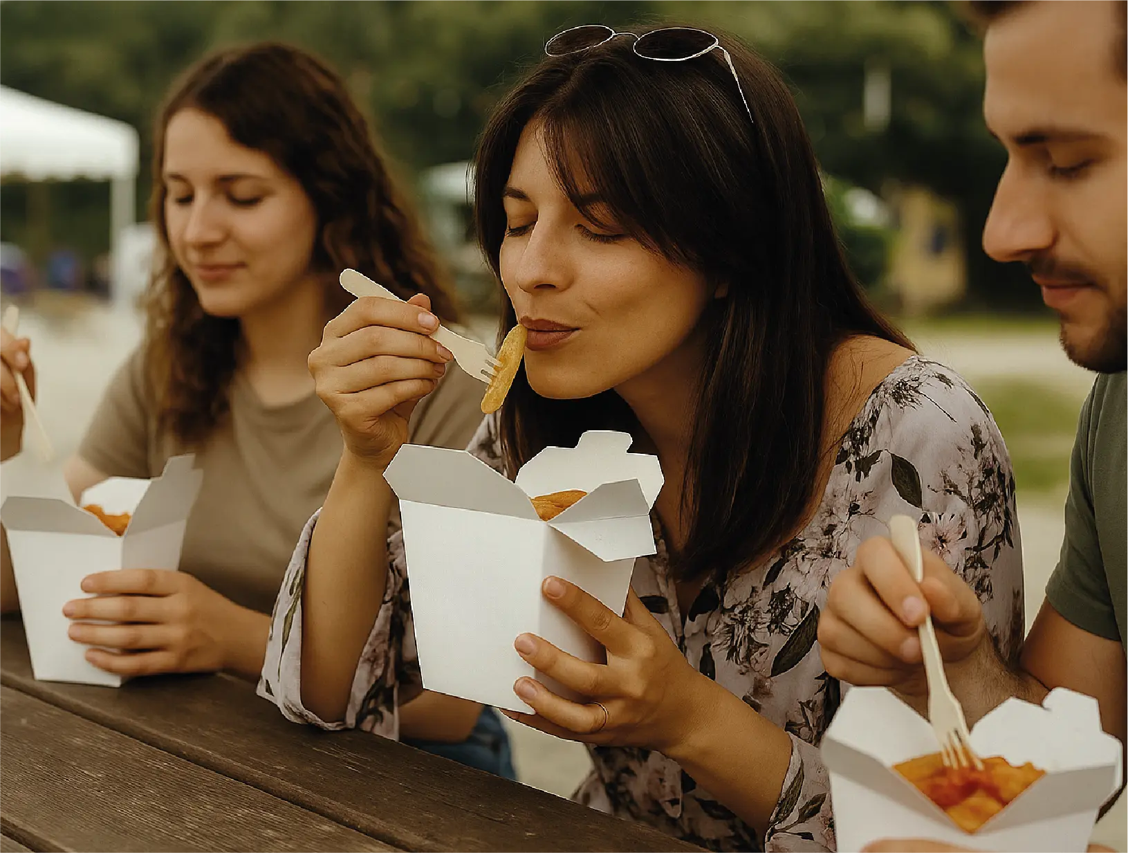Groupe d’amis dégustant des pâtes fraîches servies dans des cornets Penneke lors d’un événement en plein air à Bruxelles.