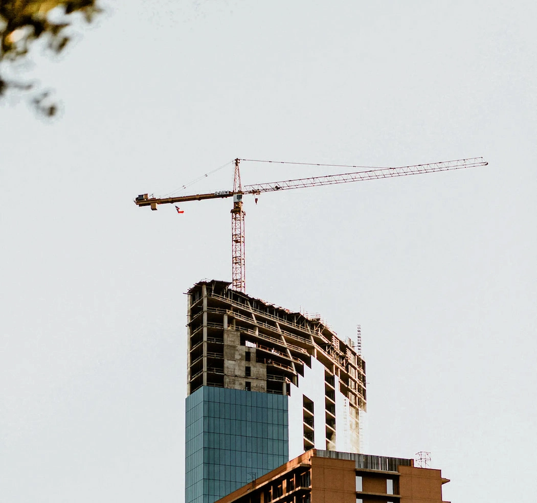 Hög byggkran vid ett storskaligt byggprojekt som illustrerar projektfinansiering via byggnadskreditiv.