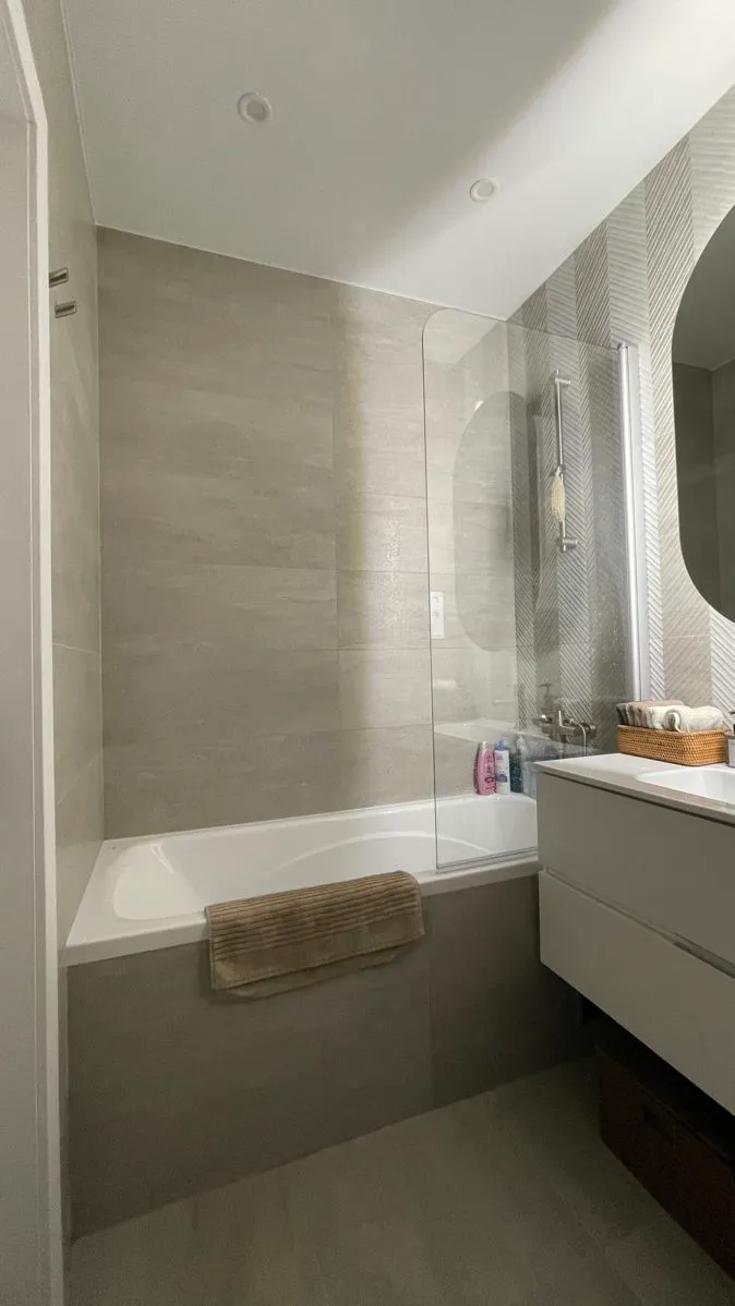 Une salle de bain avec baignoire, lavabo et miroir.