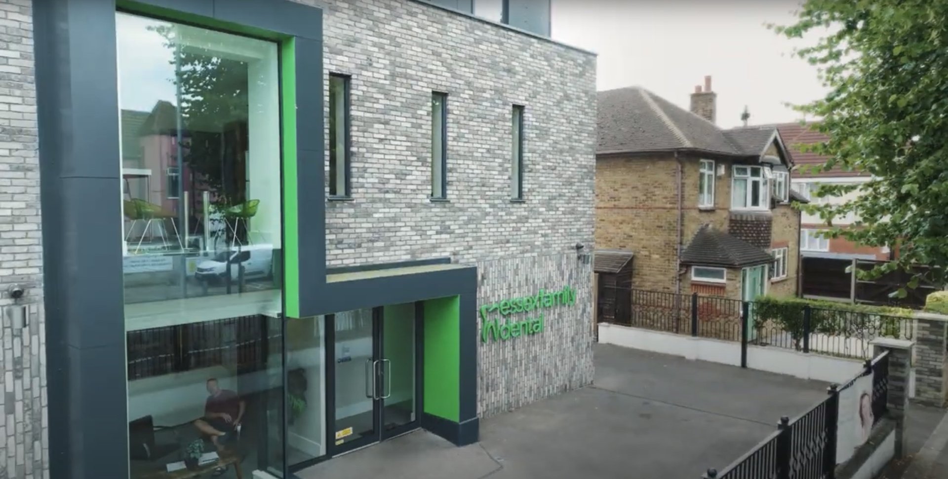 Modern brick building with large glass windows and green accents labeled 'Wessex Family Medical' next to a residential street.