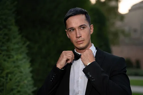 Muškarac u odelu pozira uz kameni balustrad – elegantni muški portret – Fotograf Mihajlo – Niš