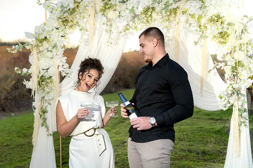 Mladenci stoje u dekorisanom dvorištu tokom fotografisanja – wedding portret – Fotograf Mihajlo – Leskovac