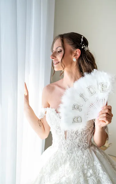 Mlada sa osmehom pozira uz dekorativni veo i perje – bridal editorial – Fotograf Mihajlo – Niš