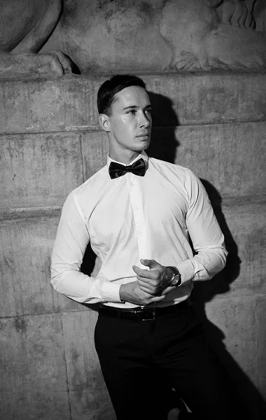 Crno-beli portret muškarca u beloj košulji uz kameni zid – muški editorial portret – Fotograf Mihajlo - Niš