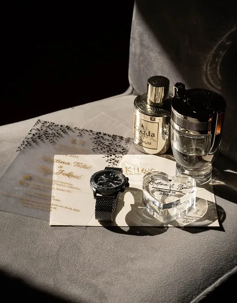 Muški svadbeni detalji u jutarnjem pripremanju – sat, parfem i pozivnica, snimljeno u Nišu prilikom pripreme za svadbu.