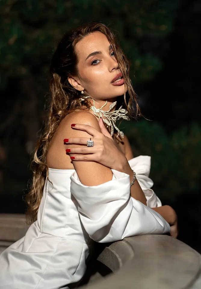 Umjetnički portret devojke u beloj haljini tokom zlatnog sata u Beogradu.