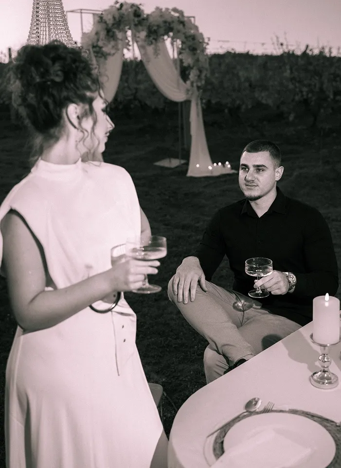 Par u opuštenom trenutku uz čaše vina tokom večernjeg portreta u vinogradu kod Leskovca.