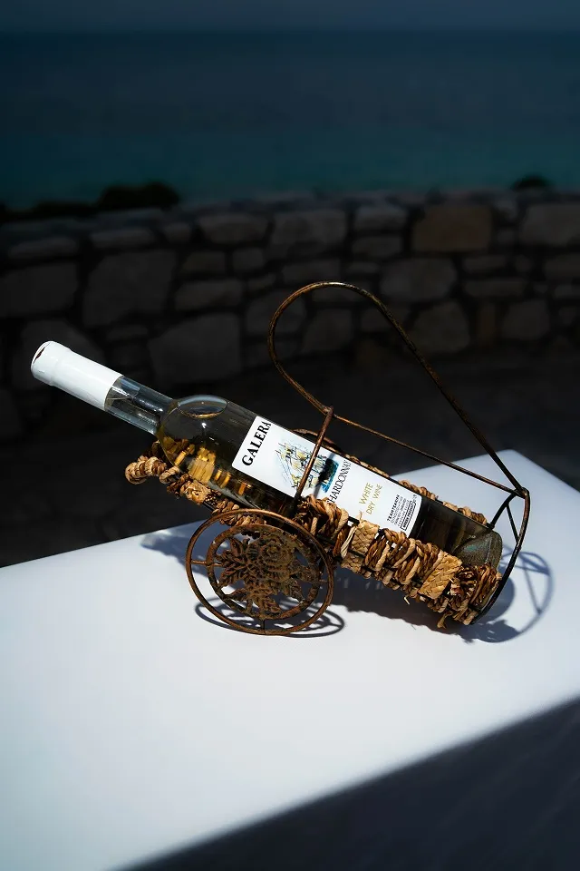 Boca belog vina u dekorativnom držaču na stolu, snimljeno na otvorenom u večernjem svetlu.