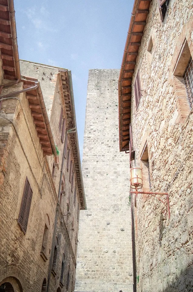 Uska kamena ulica sa tornjem u starom italijanskom gradu.