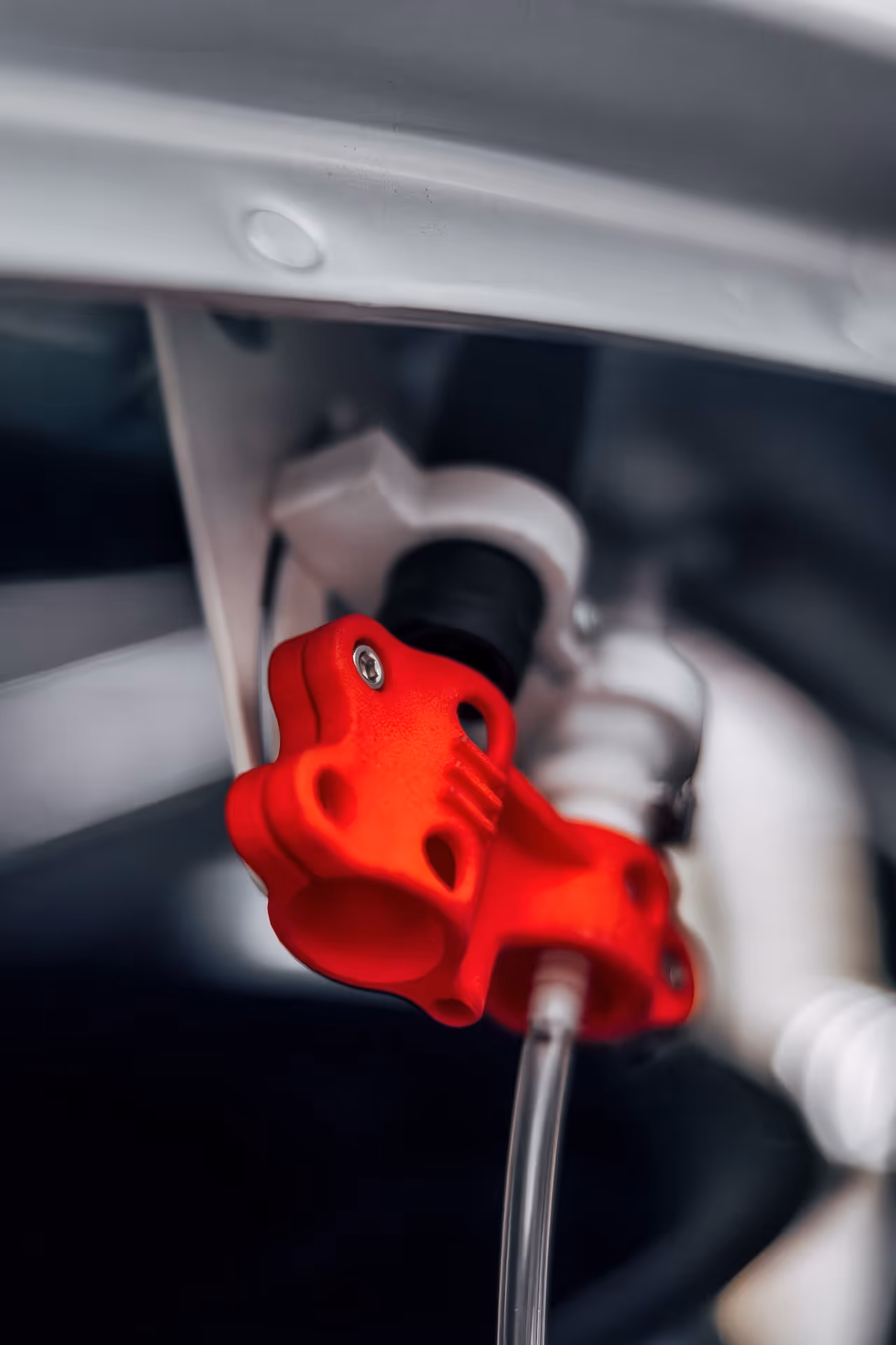 Close-up of a the connection coupling for the drivers drinking system attached to a clear tube inside of a racecar.