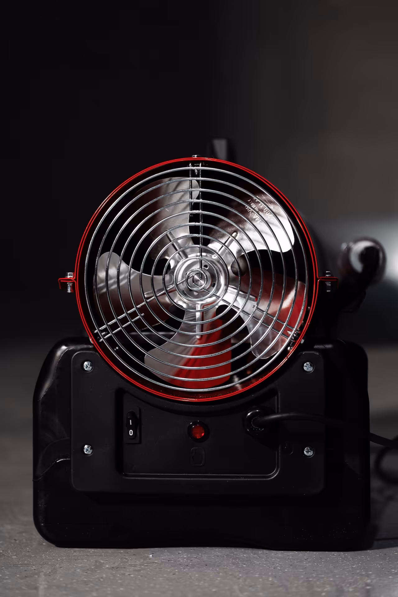 Front view of a black industrial electric fan with metal blades and a protective grille.