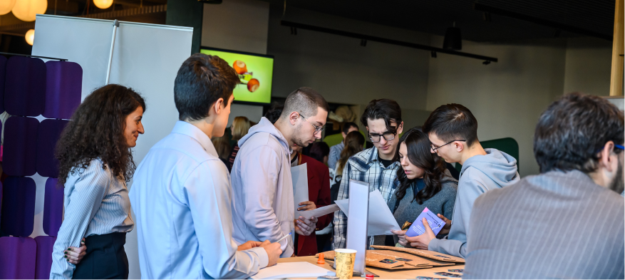 Black and white photograph of people gathered around a table.