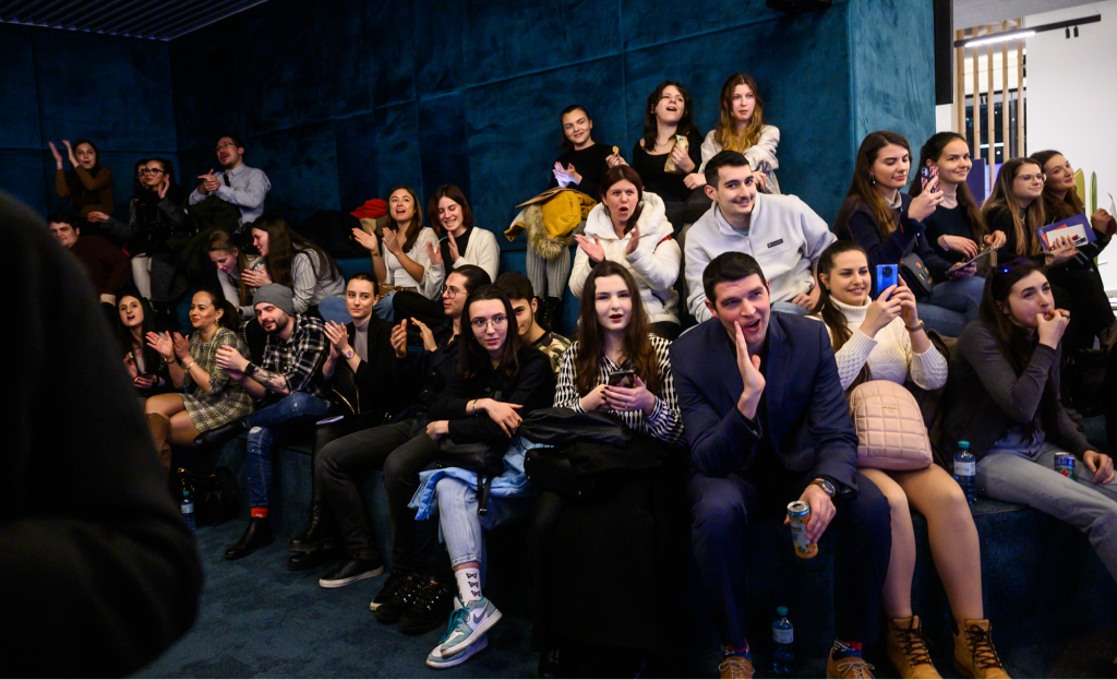 Black and white photograph of people in a room, some seated.
