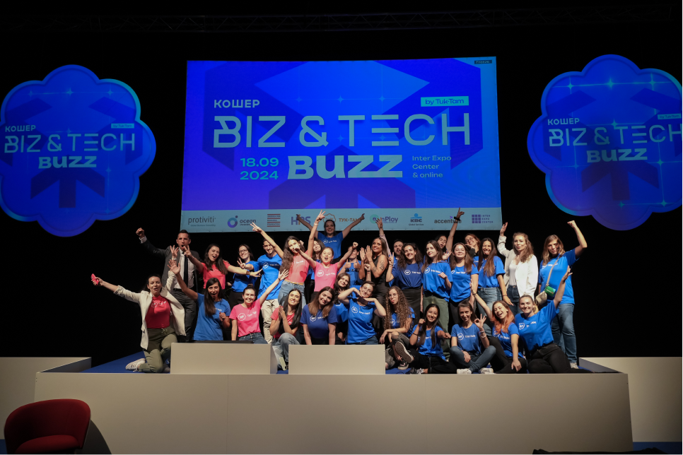 Wide-angle photograph of a large group of people posing on a stage.