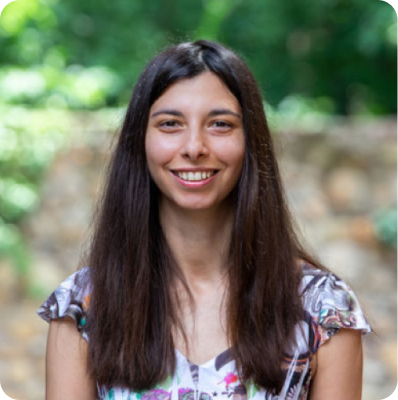 Portrait photograph of a woman with long hair, smiling.