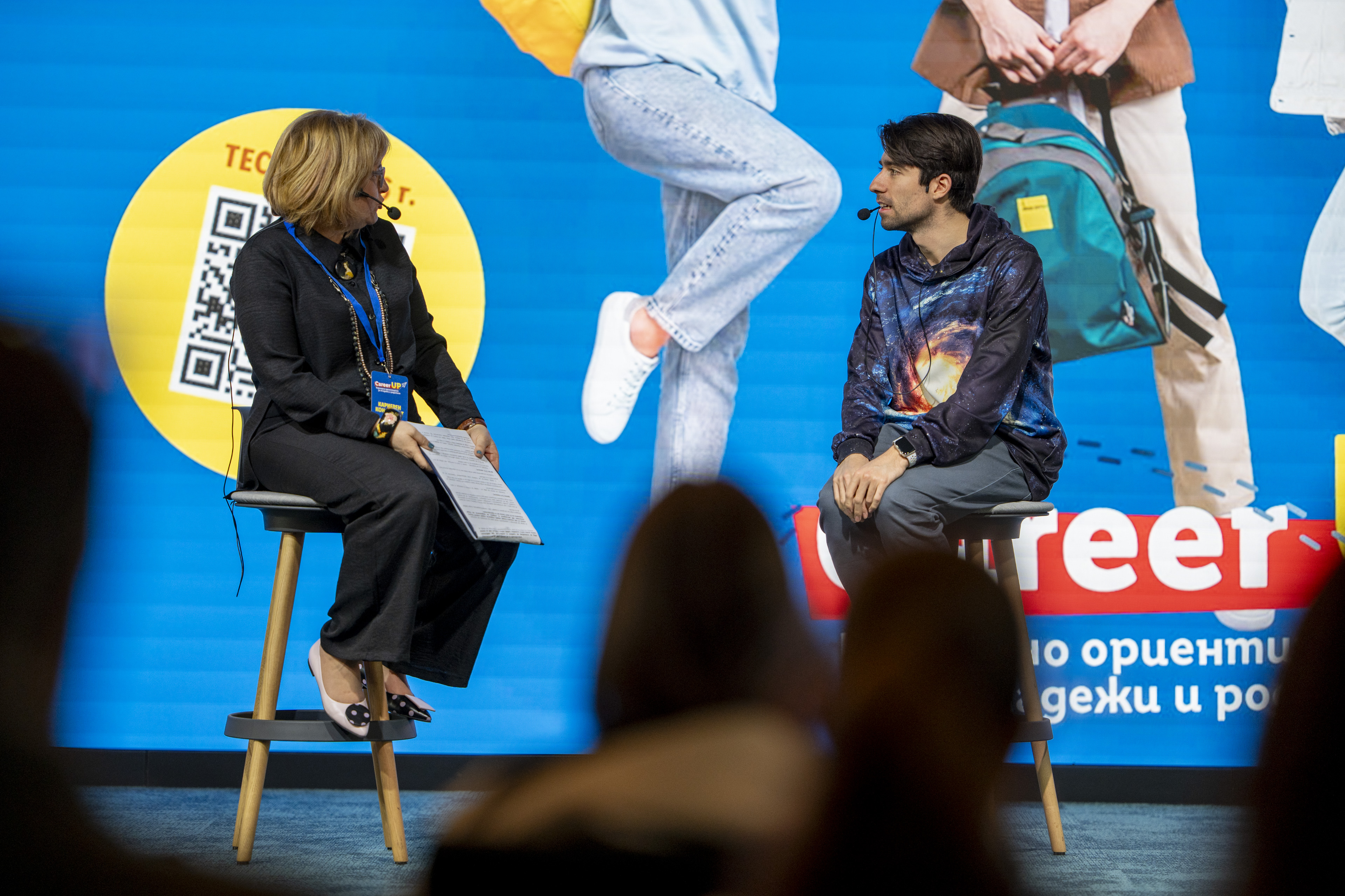 Three people talking in front of a Commerzbank display.