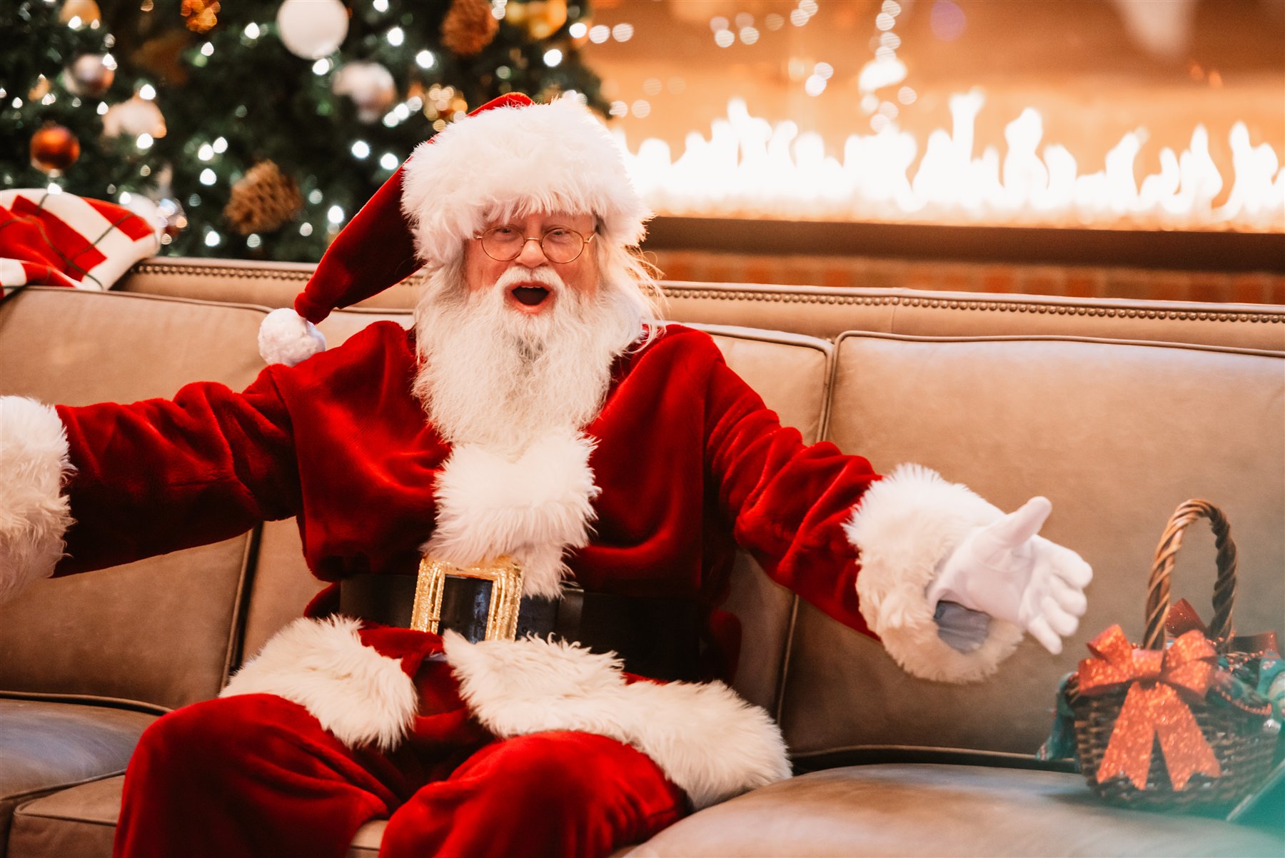 Santa Marty offering a warm welcome with open arms beside the Christmas fireplace