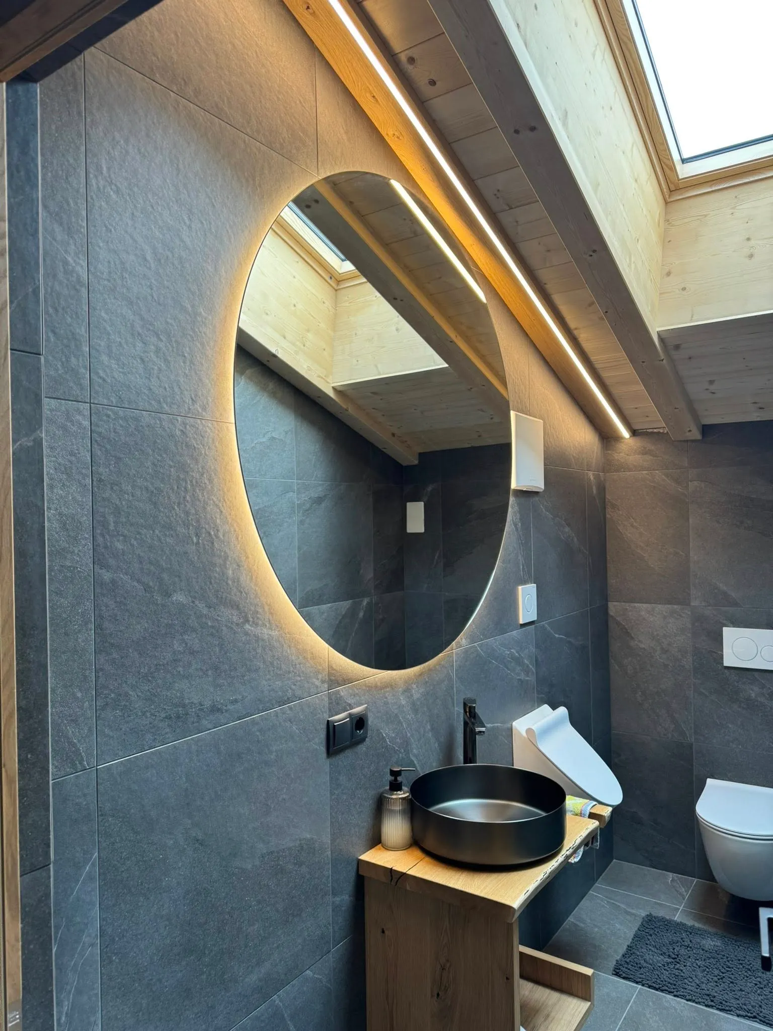 Bagno moderno con specchio illuminato e impianti elettrici.