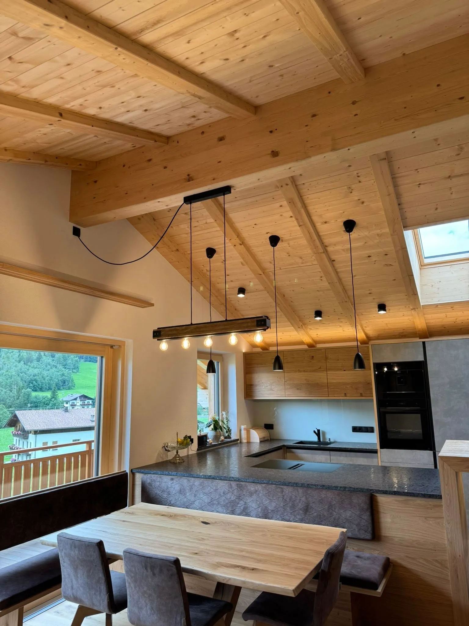 Cucina moderna con plafoniere, lampade a sospensione e illuminazione indiretta.