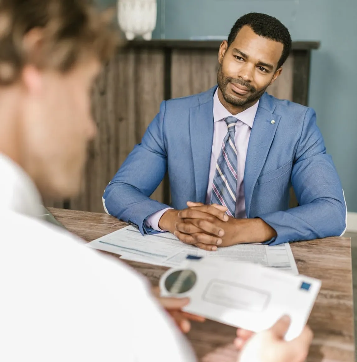 Bail bonds agent consulting with client at OnCall Bail Bonds office desk.