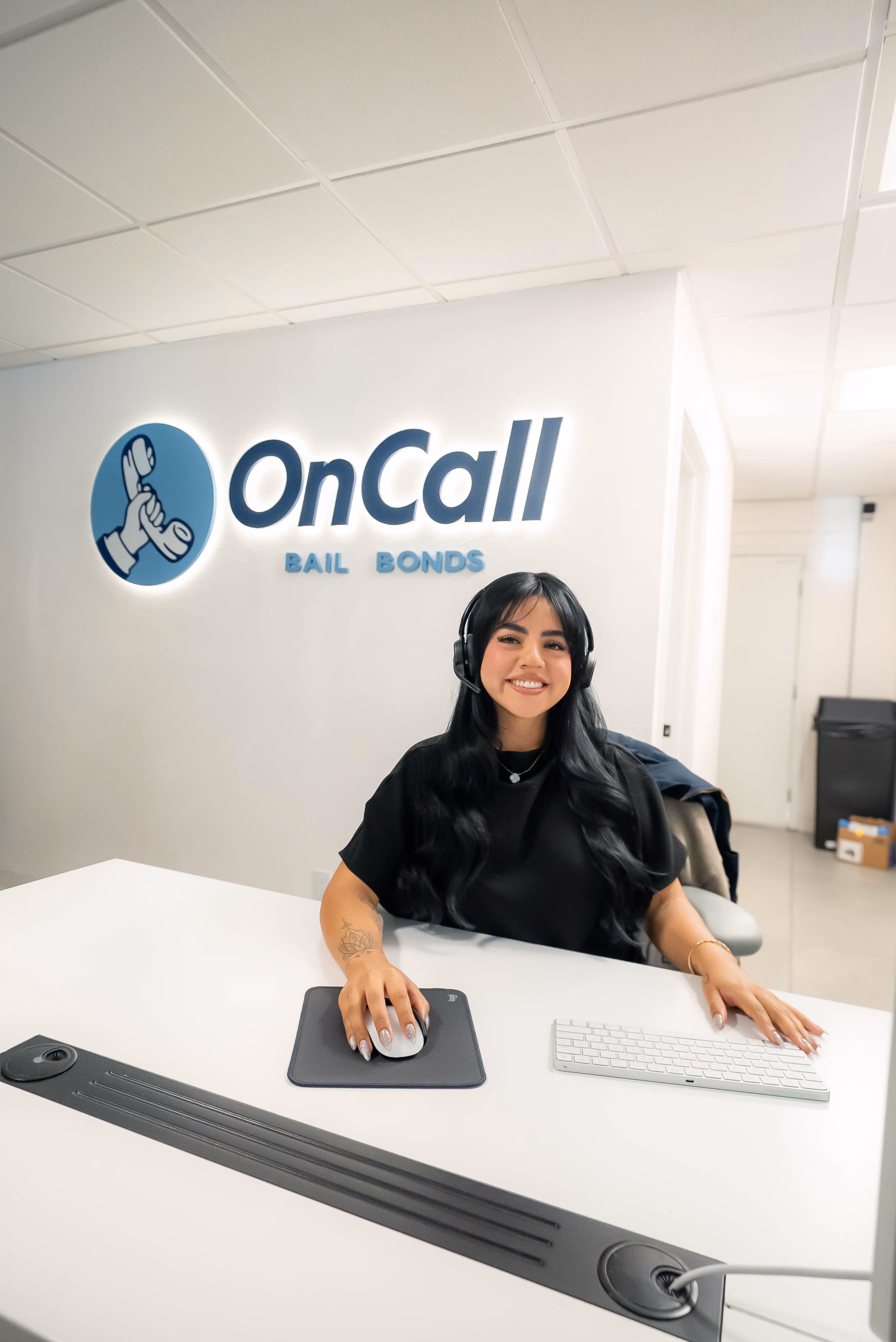 Smiling OnCall Bail Bonds agent at the front desk