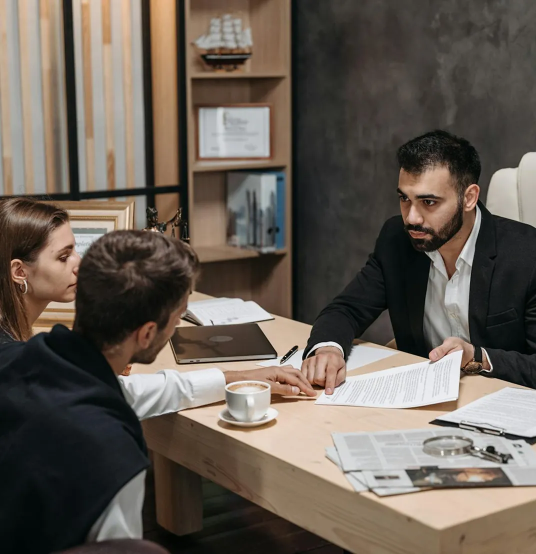 Advisor going over documents with two clients at a table