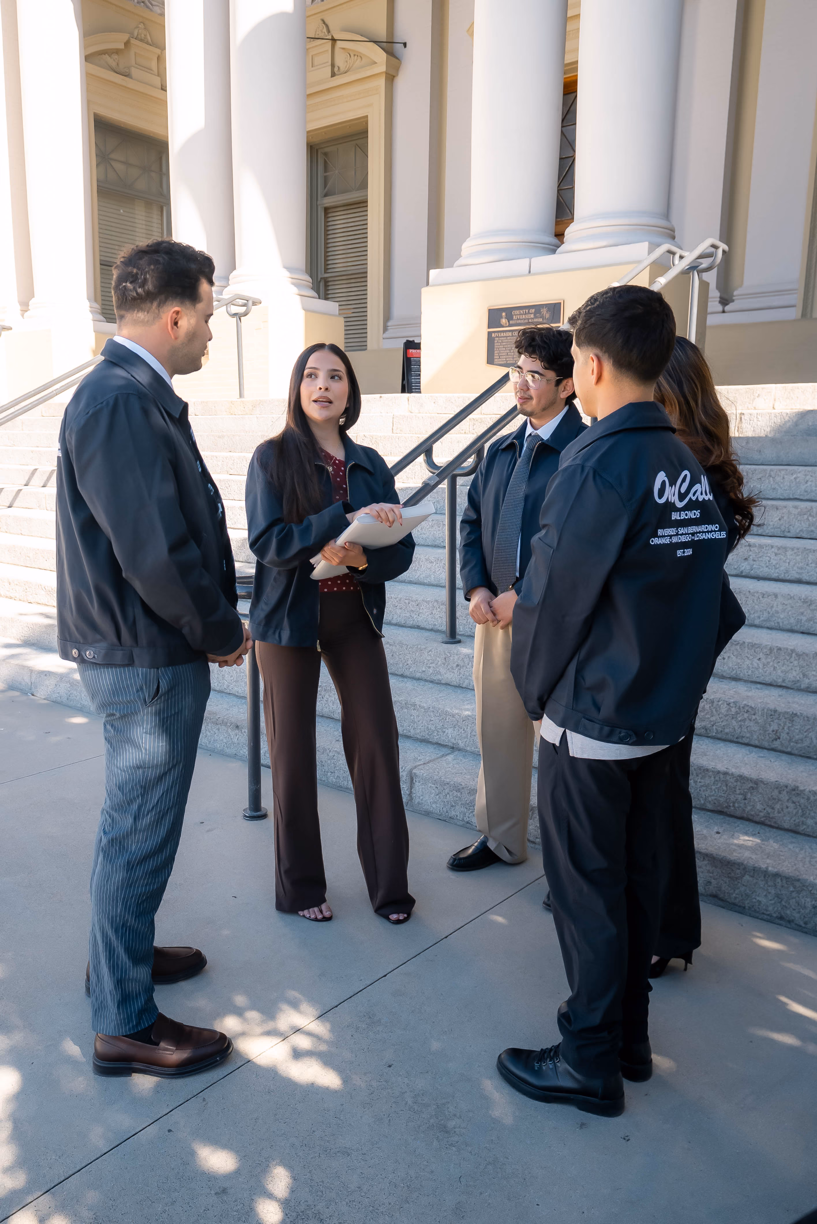 OnCall Bail Bonds team talking on the steps outside a courthouse