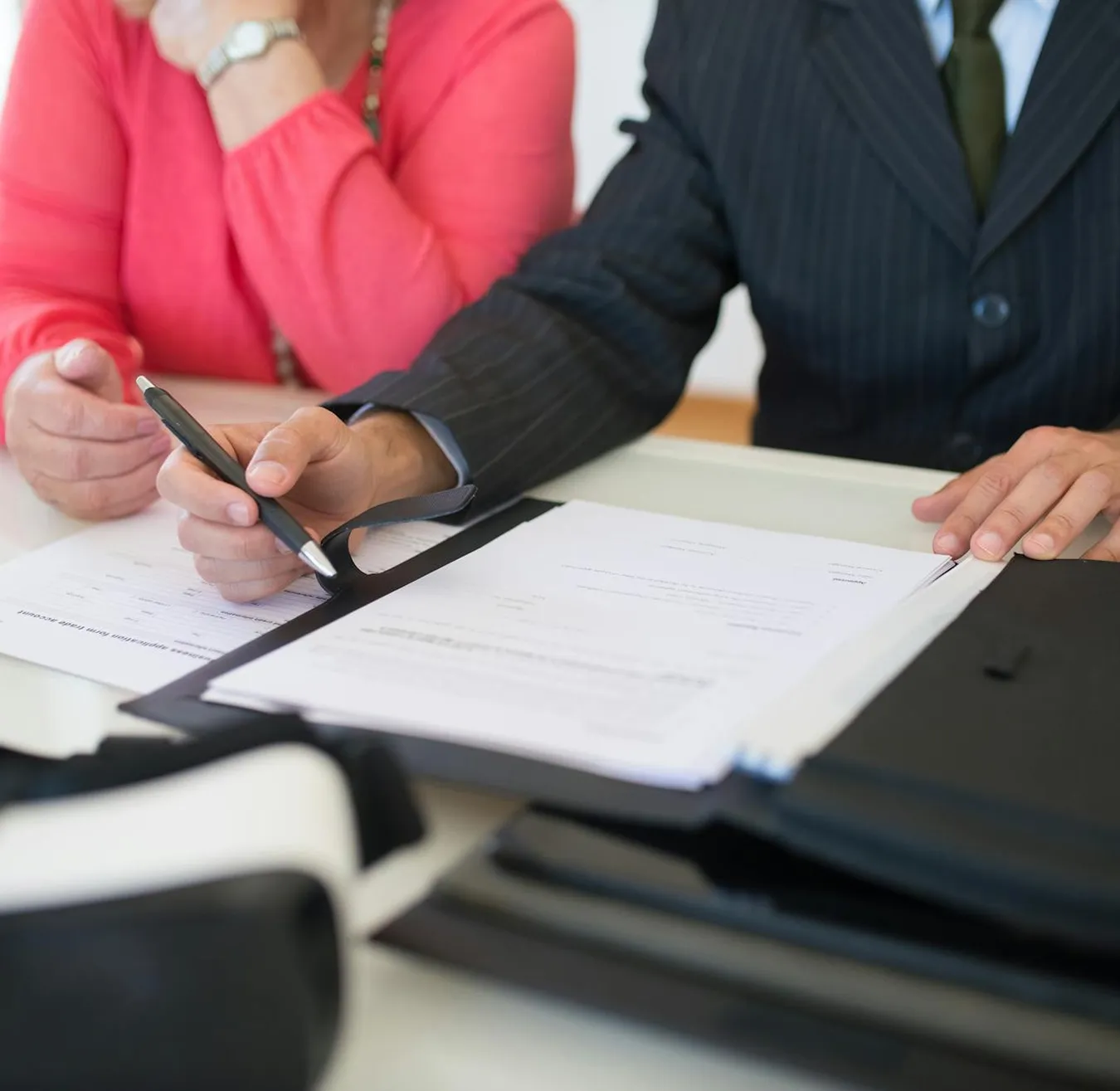 Client signing paperwork with an advisor at a desk