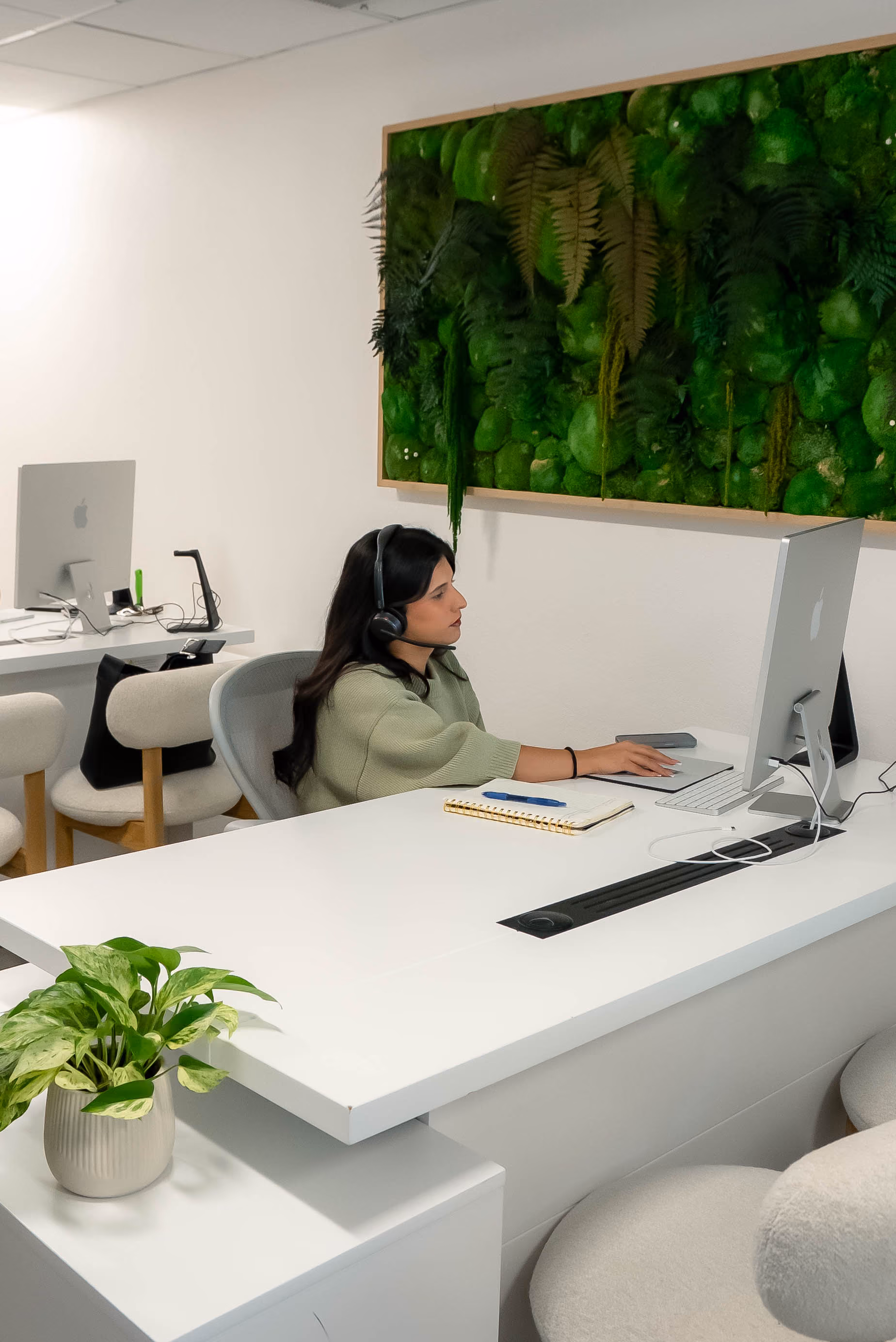 Bail agent with a headset on a call at an office desk