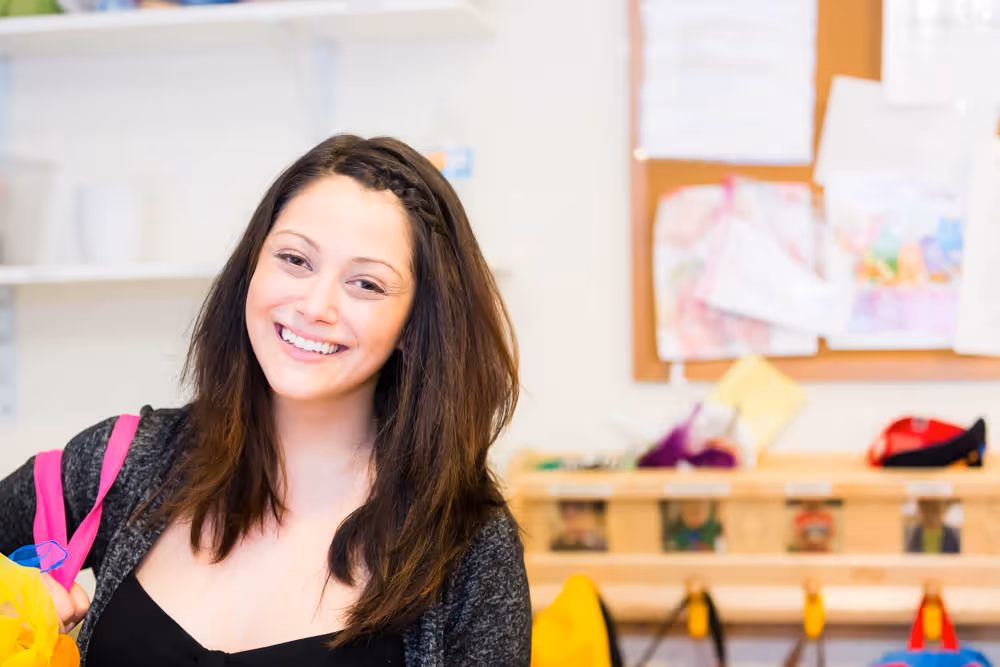 Woman smiling inside a classroom.