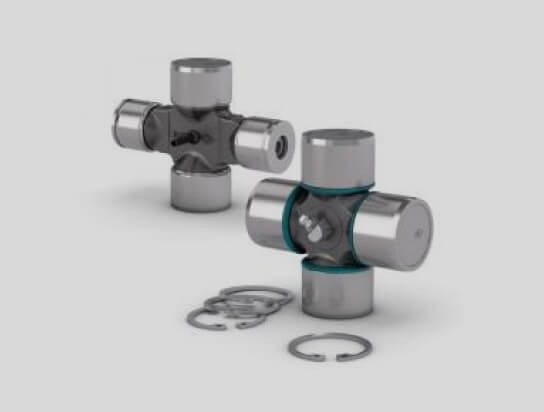 Two metal universal joint cross kits with snap rings on a light surface.
