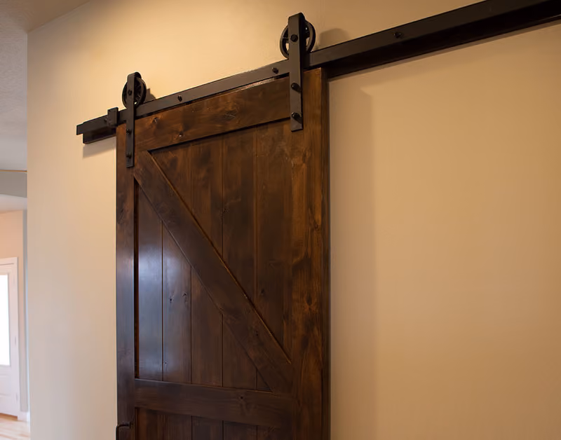 PAKCK Knotty Alder Interior Door with Black Wagon Wheel Hardware and Track Beauty Shot
