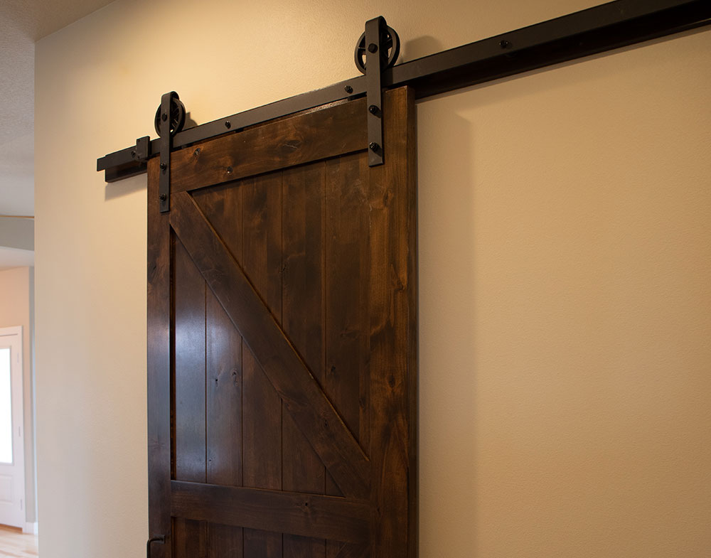 PAKCK Knotty Alder Interior Door | Black Wagon Wheel Hardware & Track