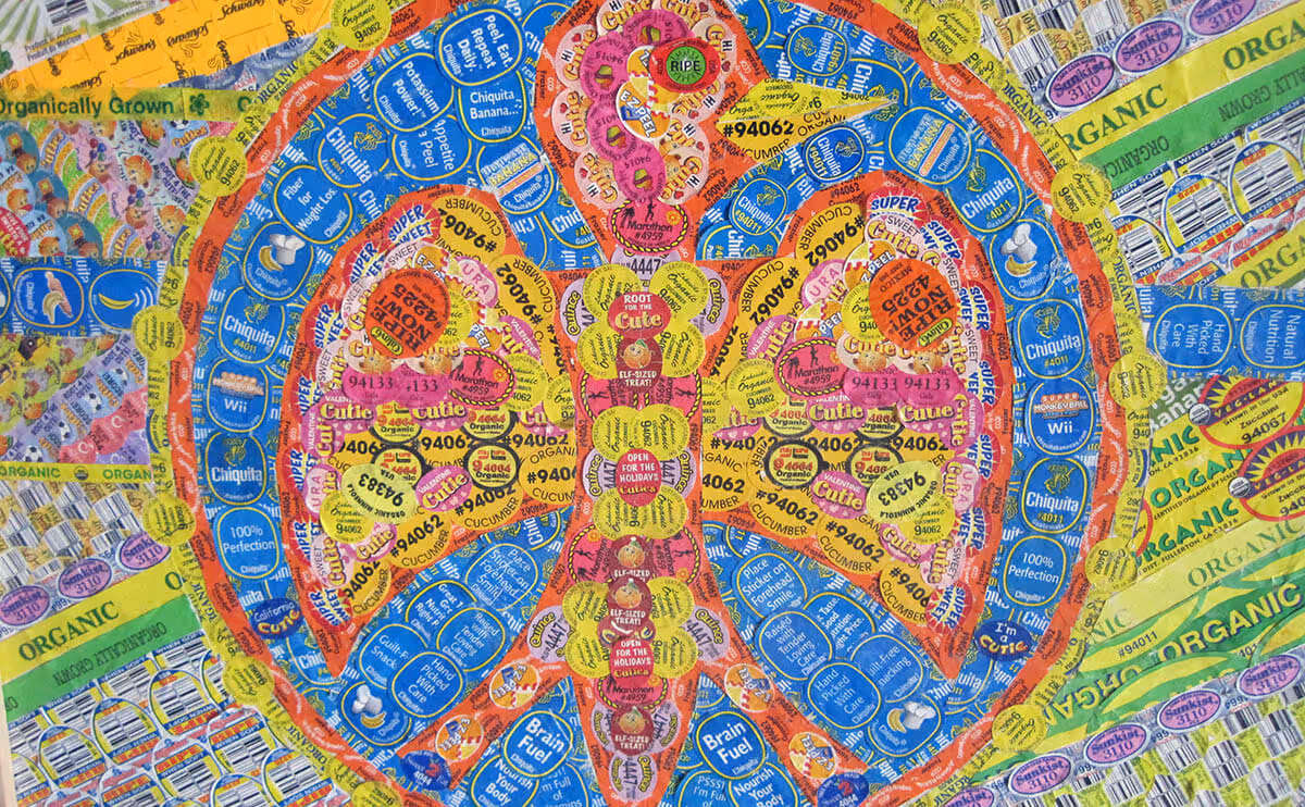 Pineapple shape made from colorful fruit stickers including Chiquita, Cutie, and organic labels.