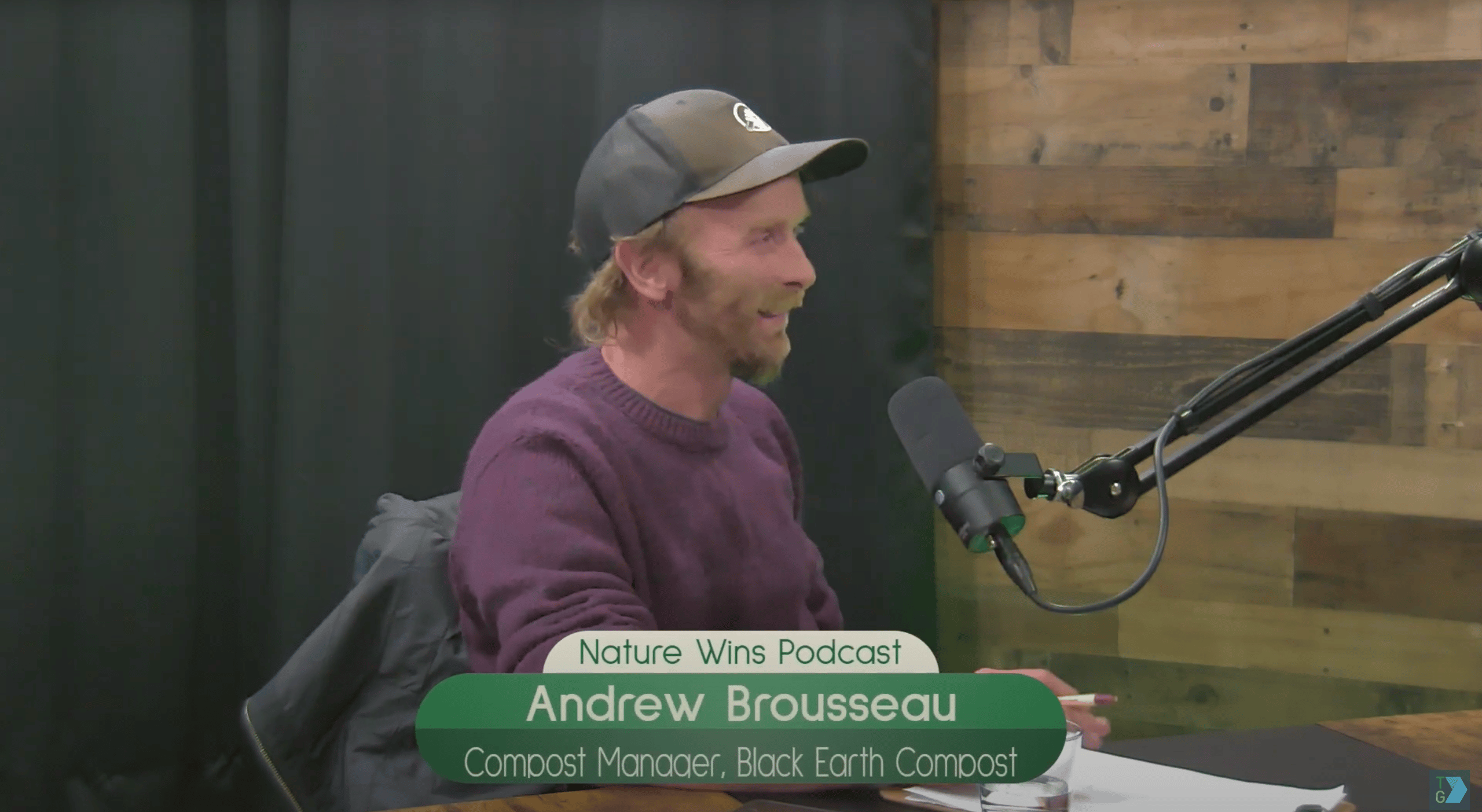 Andrew Brousseau, Compost Manager at Black Earth Compost, speaking into a microphone on the Nature Wins Podcast.