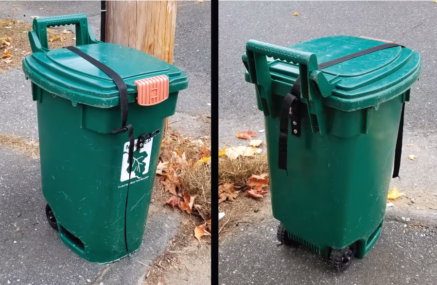 Green outdoor wheeled trash bin with a black strap securing the lid, shown from two angles on a paved surface near a wooden post.