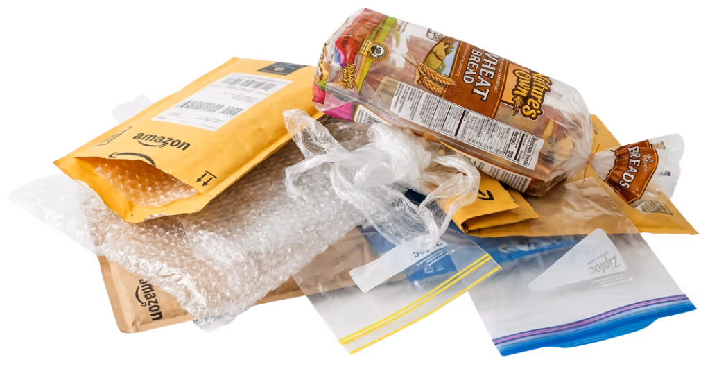 Various flexible plastic items including bubble wrap, Amazon padded mailers, a loaf of bread in plastic packaging, and two Ziploc bags.