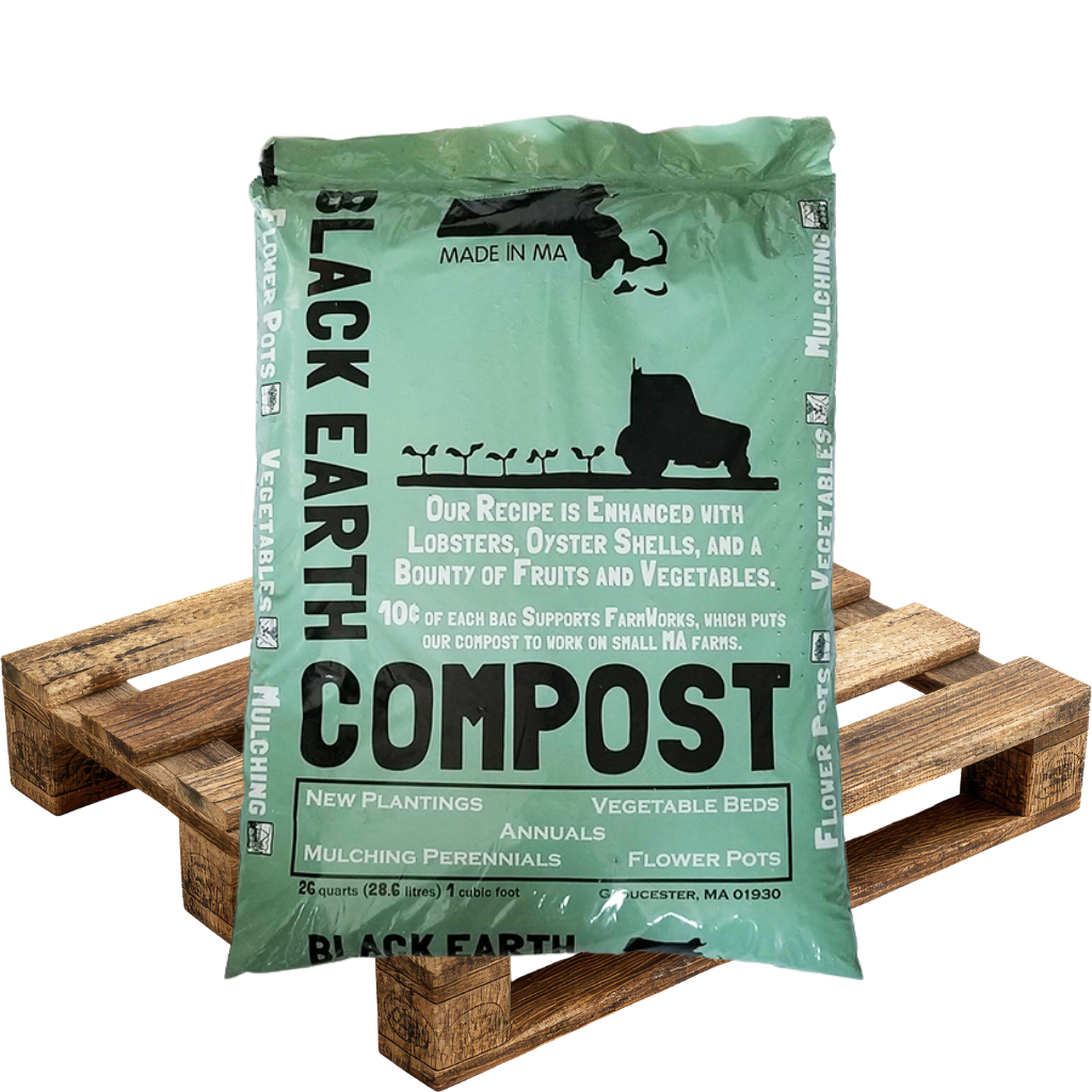 Green bag of Black Earth compost showing text about enhanced recipe with lobsters, oyster shells, fruits, and vegetables, placed on a wooden pallet.