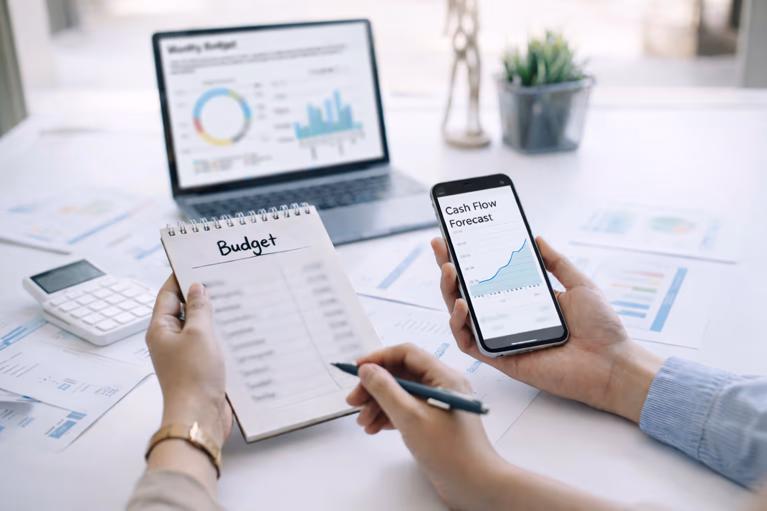 Woman staring down at papers strewn across her kitchen table, visibly stressed about budgeting.