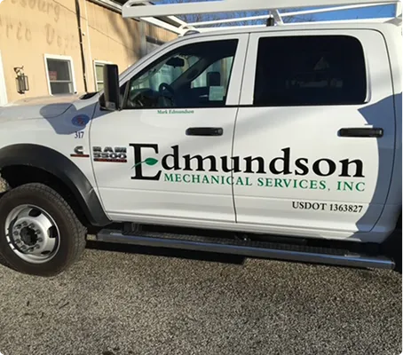 Side view of a white Ram pickup truck with Edmundson Mechanical Services, Inc. logo on the door.