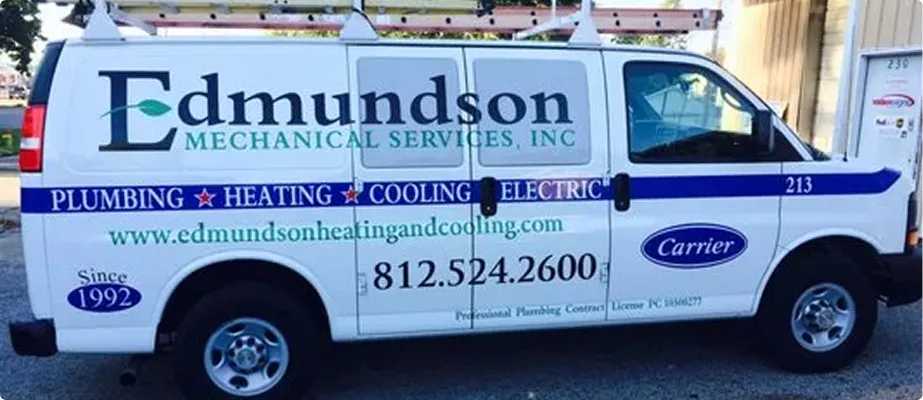 White service van for Edmundson Mechanical Services displaying plumbing, heating, cooling, and electric services with contact info and Carrier logo.