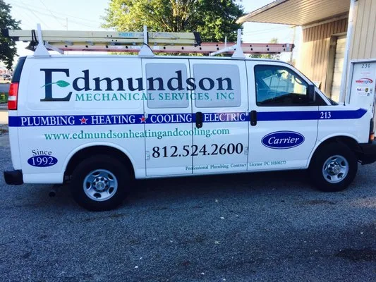 White service van for Edmundson Mechanical Services, Inc. with blue and green lettering advertising plumbing, heating, cooling, and electric services, including website and phone number.