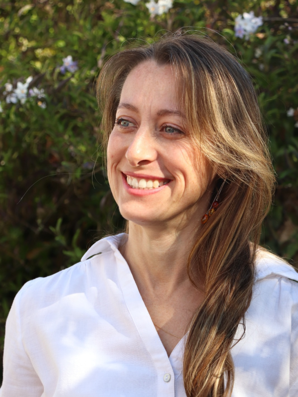 Portrait de Pamela, avec une chemise blanche, sur fond vert et regardant vers la gauche