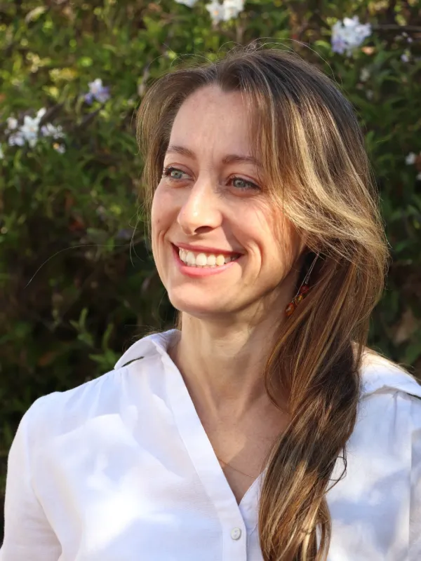 Portrait de Pamela, avec une chemise blanche, sur fond vert et regardant vers la gauche