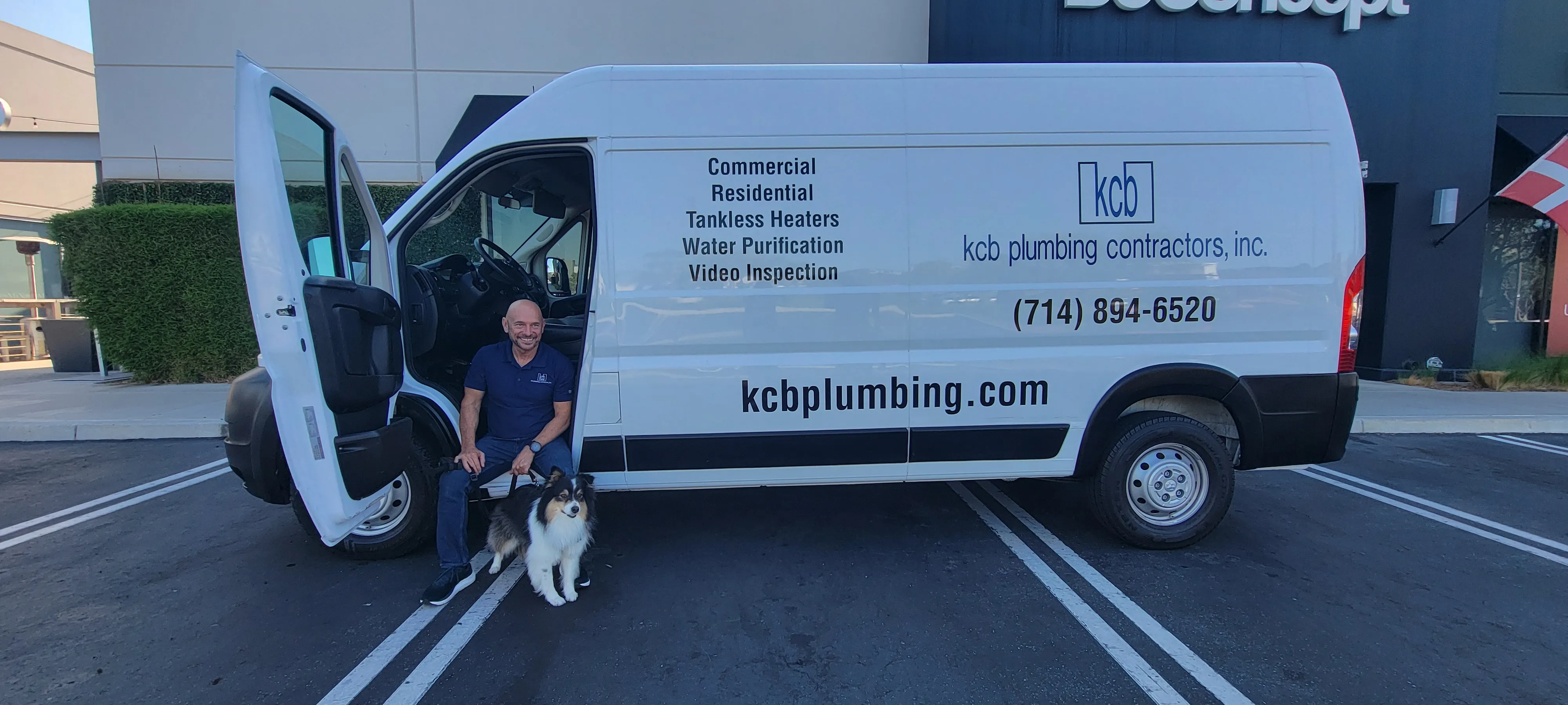 Keevin Blue, KCB Plumbing owner, with dogs in front of service van