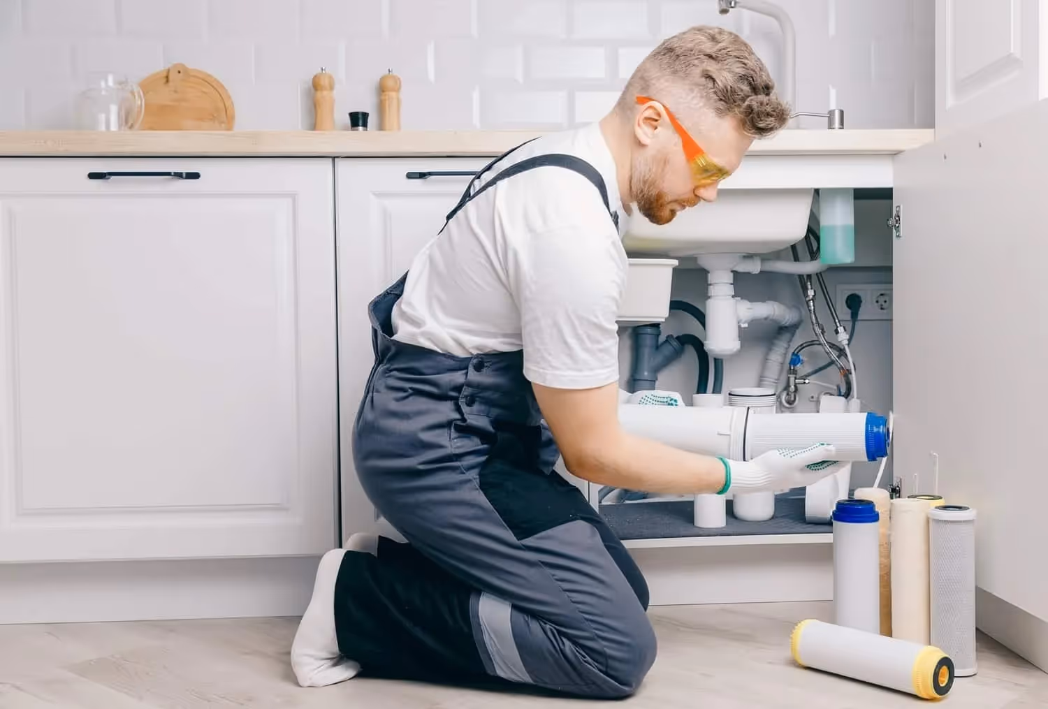 Plumber replaces under-sink water filter cartridge.