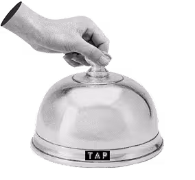 A black and white image of a hand holding a cloche. The cloche has a label that reads 'tap' 