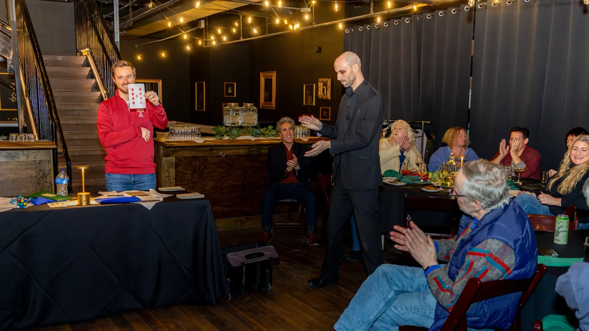 Magician lets audience member handle the cards in Duane Morris Plaza