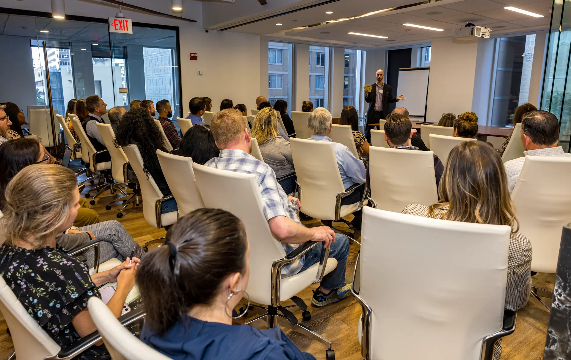 Jesse Dameron presents to a seated audience of Kleinbard LLC employees arranged in a theater-style square